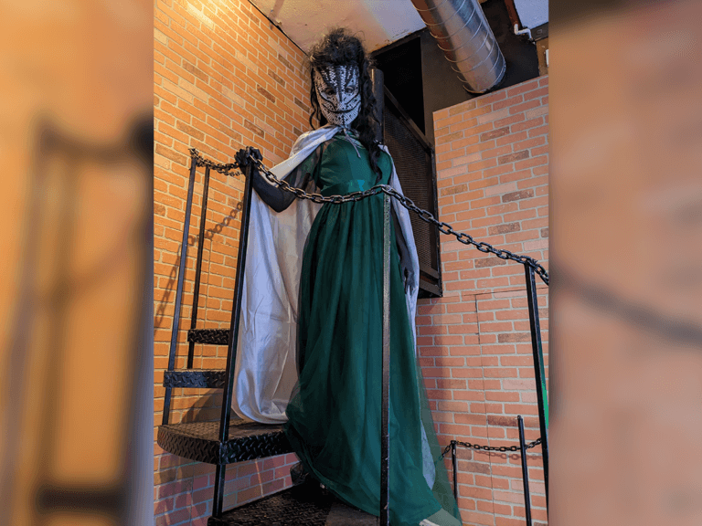 Audrey Del Prete in a snake costume with a green dress and white cape.